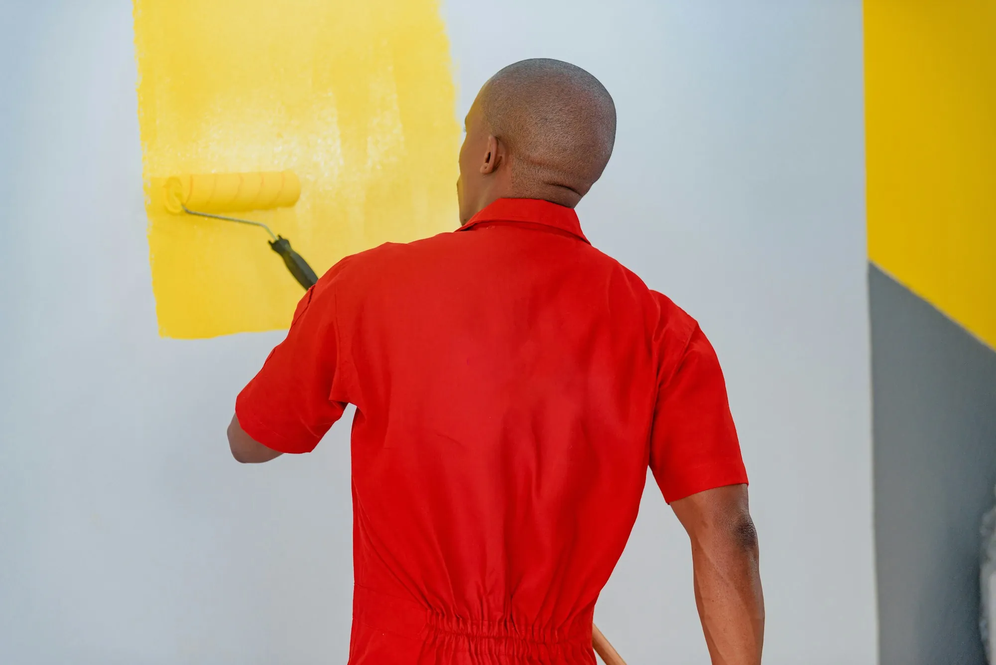 Painter cutting in a clean line where the wall meets the ceiling